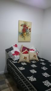 a bed with pillows on it in a room at Studio mobiliado in Santos