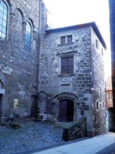 ein altes Steingebäude mit einer Tür und einem Fenster in der Unterkunft Chambres d'hôtes La Prévôté - Ancien couvent contre la Cathédrale in Le Puy en Velay