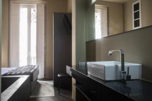 ein Bad mit einem Waschbecken und einem Bett in der Unterkunft Cosy Rooms Tapinería in Valencia