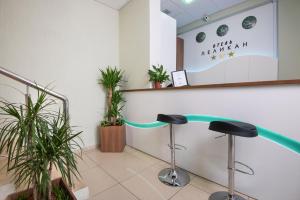 una sala de espera con dos taburetes y plantas en Hotel Pelican, en Krasnodar