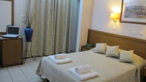 
a hotel room with two beds and a table at Hotel Solomou in Athens
