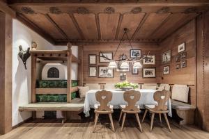 a dining room with a white table and chairs at Hotel Tyrol in Selva di Val Gardena