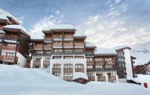 un edificio con nieve delante en Résidence Odalys La Licorne, en La Plagne