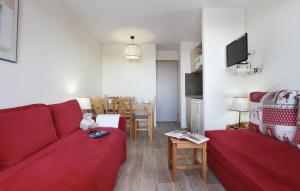 een woonkamer met een rode bank en een tafel bij Résidence Odalys La Licorne in La Plagne