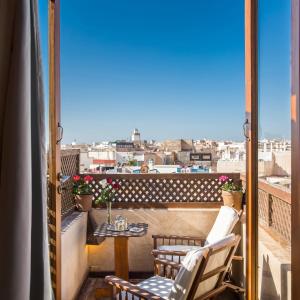 a balcony with a table and chairs and a view at Riad Chbanate in Essaouira