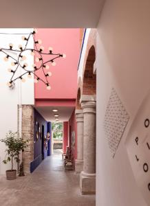 Ambronay的住宿－La Maison d'Ambronay，粉红色天花板的建筑走廊