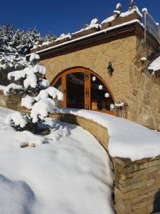 a snow covered cabin with a door and a pile of snow at Skalny Zakątek z Grotą Solną na wyłączność in Łapsze Niżne