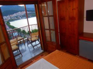 a room with a balcony with a view of the water at Guesthouse Filoxenia in Kastoria