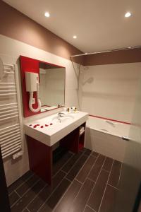 uma casa de banho com um lavatório, um espelho e uma banheira em Hotel Lyon-ouest em Lyon