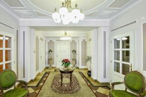 a hallway with a table and chairs and a chandelier at Residence Romanza in Mariánské Lázně