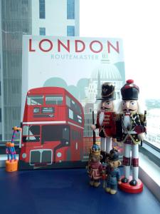 two toy figures standing next to a red double decker bus at Eye of London @ Central Malacca in Malacca
