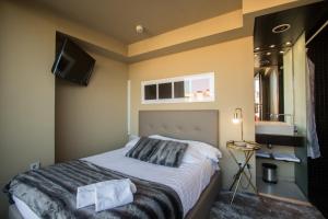 a bedroom with a bed and a tv on the wall at Cosy Rooms Tapinería in Valencia