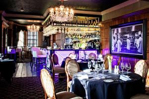 a dining room with a table and a bar at Ye Olde Bell Hotel & Spa in Retford