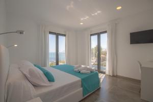 a white bedroom with a large bed with windows at Son Serra de Marina - 1930-45 Mallorca in Son Serra de Marina +19 photos