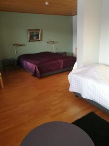 een slaapkamer met 2 bedden en een houten vloer bij Hotelli Puustelli Lieksa in Lieksa