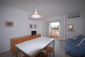 a living room with a white table and a blue chair at Appartamenti Luna in Lignano Sabbiadoro