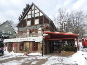 een groot houten gebouw met sneeuw op de grond bij Paul Lincke Residenz in Hahnenklee-Bockswiese