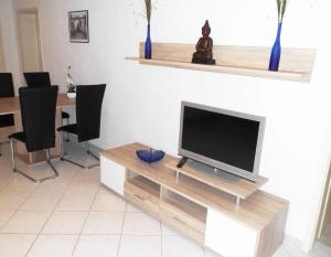 a living room with a television on a wooden entertainment center at Ferienwohnung Botschafter in Wendelstein