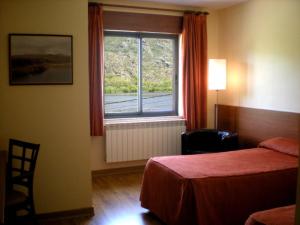 Tempat tidur dalam kamar di Hotel Don Pepe Lago de Sanabria