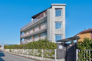 an apartment building with a fence and a bus stop at AppartaHotel in Beinasco