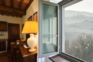 a window in a room with a lamp on a desk next to a window at Castello di Fulignano Soarzio panoramic apartment in San Gimignano