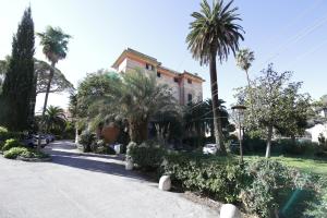 a house with palm trees in front of a street at Hotel Villa Bonera in Genoa