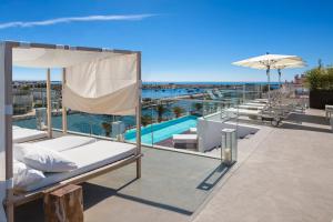 a balcony with a bed and an umbrella and a pool at Lagos Avenida Hotel in Lagos