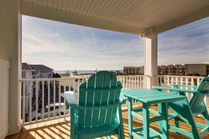 a patio with two chairs and a table on a balcony at Islander Hotel & Resort in Emerald Isle