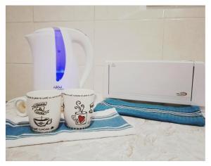 Zwei Kaffeetassen stehen auf einer Arbeitsfläche neben einem Mixer. in der Unterkunft Studio Leonidas Vis in Vis