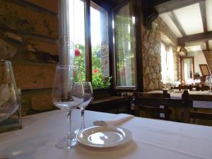 due bicchieri da vino seduti su un tavolo in un ristorante di Logis Hotel Restaurante La Casa de Juansabeli a Arenas de Cabrales