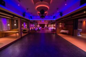 a dance floor in a ballroom with purple lights at Hotel Zum Fischerwirt in Baindlkirch