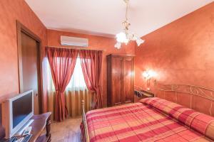 um quarto com uma cama e uma televisão em Locanda del Borgo em Todi