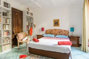 ein Schlafzimmer mit einem Bett, einem Stuhl und Bücherregalen in der Unterkunft Naples Center Apartment in Neapel