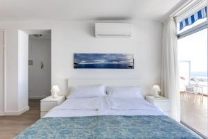 biała sypialnia z łóżkiem i dużym oknem w obiekcie Penthouse direkt am Meer w mieście Los Realejos