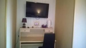 TV a/nebo společenská místnost v ubytování Hotel Le Beauregard