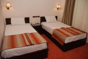 Łóżko lub łóżka w pokoju w obiekcie EL Tonsy Hotel
