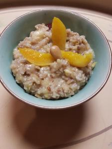 a bowl of oatmeal with orange slices on top at Mak in Murowana Goślina