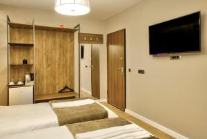 a hotel room with two beds and a flat screen tv at Boulevard Prishtina in Pristina