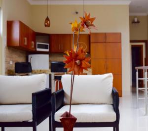 a vase with flowers on top of two chairs in a kitchen at Hotel Apart Guayaquil Aeropuerto in Guayaquil
