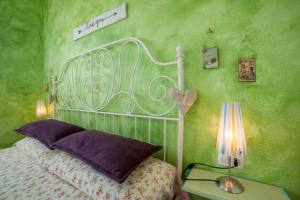 ヴァッレドーリアにあるCasa Vacanza Sardegnaの緑の壁、ベッド付きのベッドルーム1室