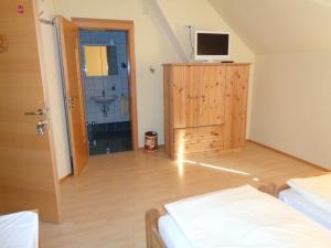 Pension Himmelreich في Ternitz: غرفة نوم مع تلفزيون على رأس خزانة خشبية