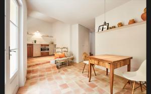 a kitchen and dining room with a wooden table at Mas De La Baume in Lafare