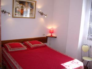 a red bed with two red pillows in a bedroom at Chalet Les Lupins T2 in Font-Romeu
