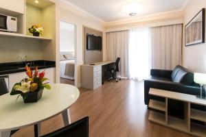 a living room with a couch and a table at Tsue The Palace Flats in Sao Paulo