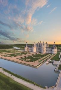 una vista aérea del palacio de Versalles con un lago en domaine des chevrettes, en Cour-Cheverny