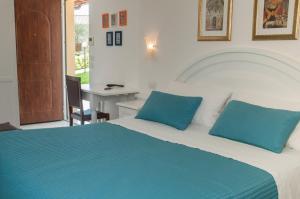 1 dormitorio con cama con almohadas azules y escritorio en Agriturismo Il Casale di Monica, en Rivotorto