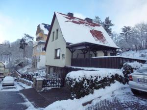 ein schneebedecktes Haus mit einem Auto vor dem Haus in der Unterkunft FeWo Wernigerode in Wernigerode