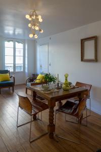 - un salon avec une table et des chaises en bois dans l'établissement Appartements Avignon Centre, à Avignon