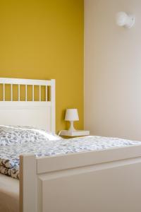 ルッケンヴァルデにあるAnnes Pensionのベッドルーム1室(白いベッド1台付)と黄色い壁