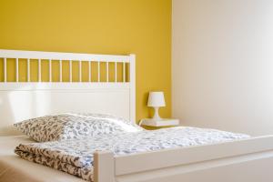 ルッケンヴァルデにあるAnnes Pensionのベッドルーム1室(白いベッド1台付)と黄色い壁